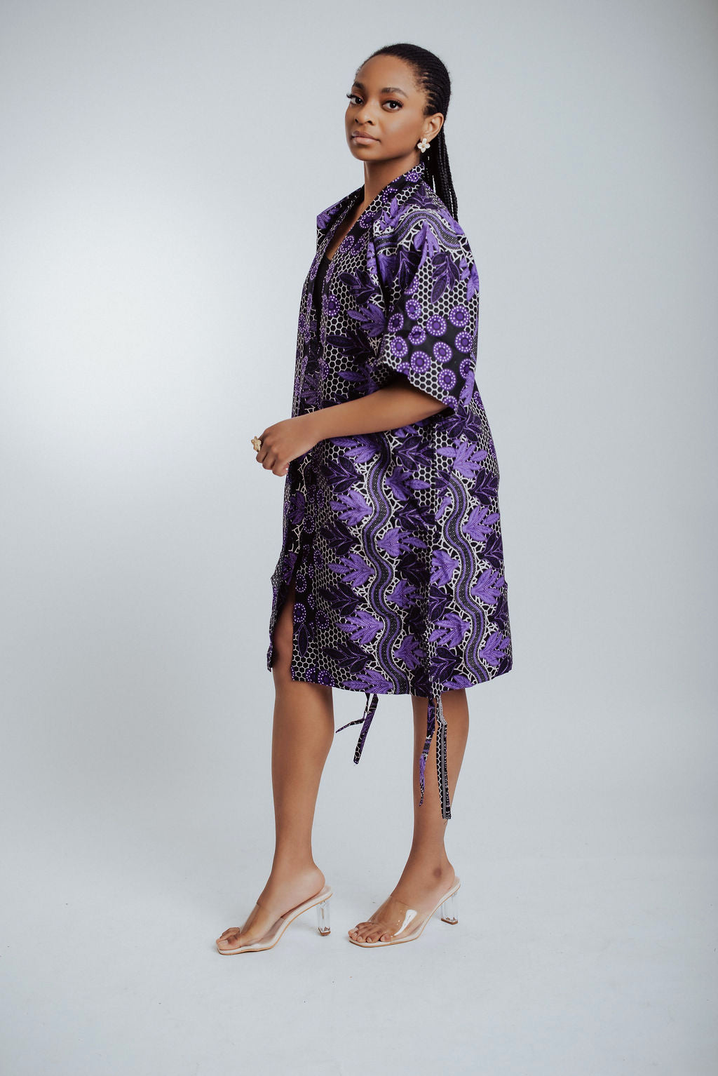 Side view of woman wearing a purple patterned kimono on a white background