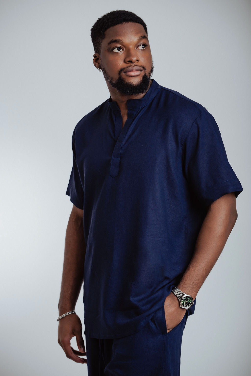 Man wearing a navy blue outfit against a plain background