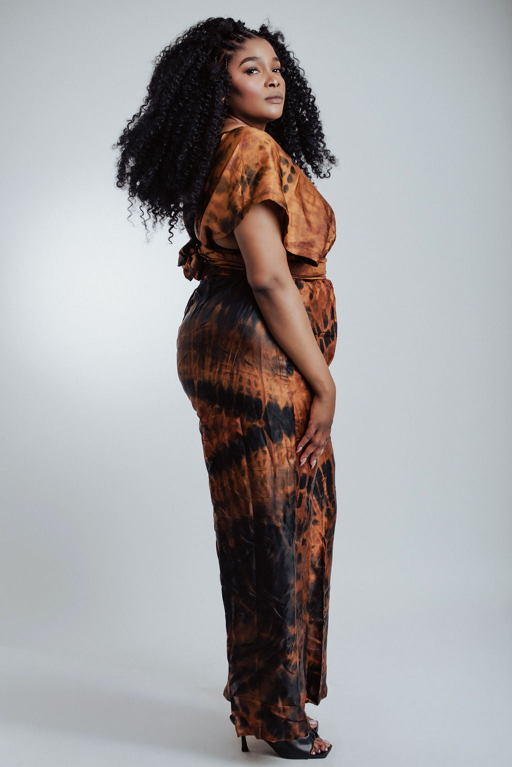 Woman wearing a tie-dye jumpsuit on a white background