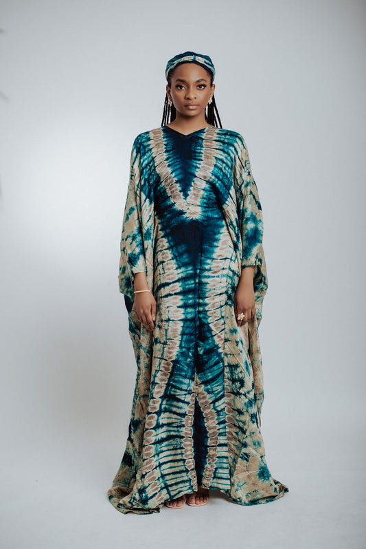 Woman wearing a green & cream tie-dye dress on a white background