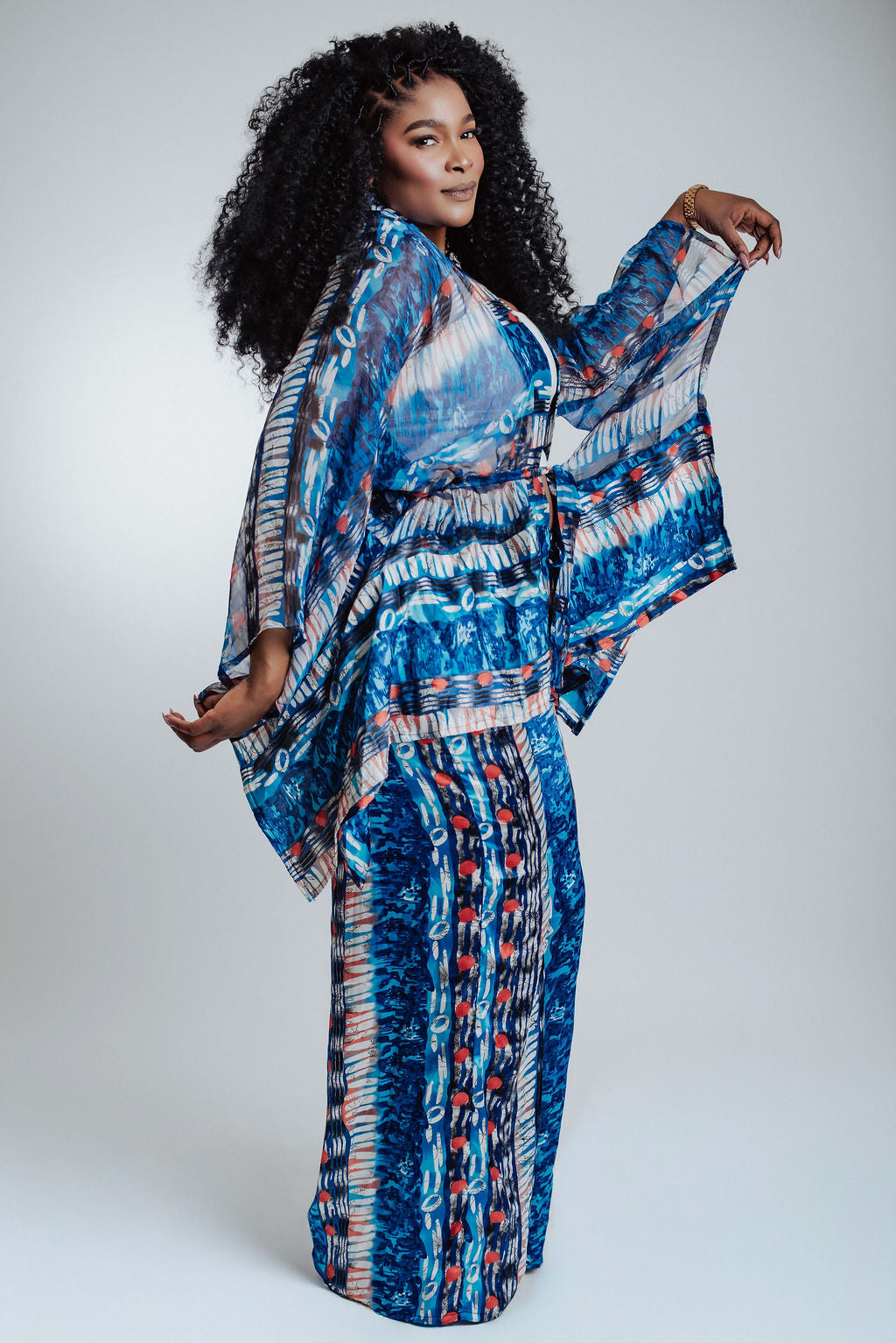Woman wearing blue patterned pants and kimono set on a white background 