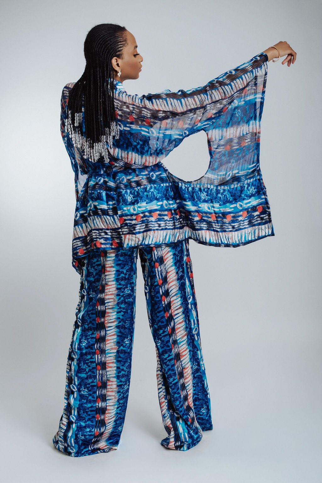 Woman wearing blue patterned pants and kimono on a white background 