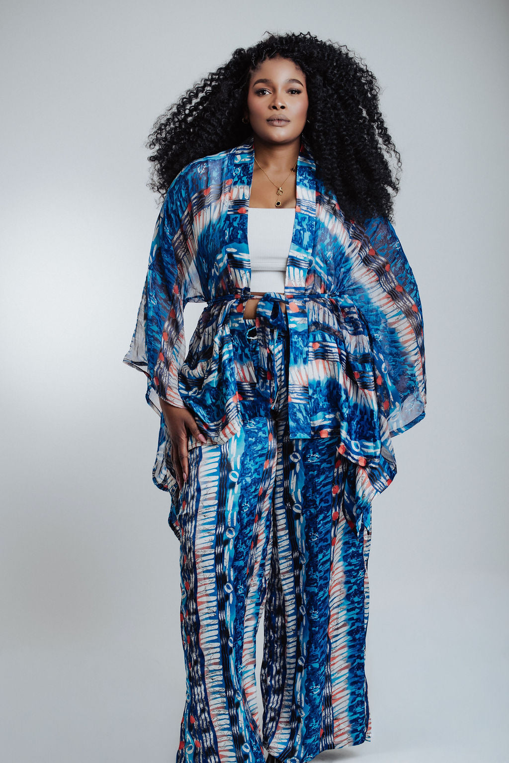 Woman wearing a blue and white patterned kimono-style outfit on a plain background