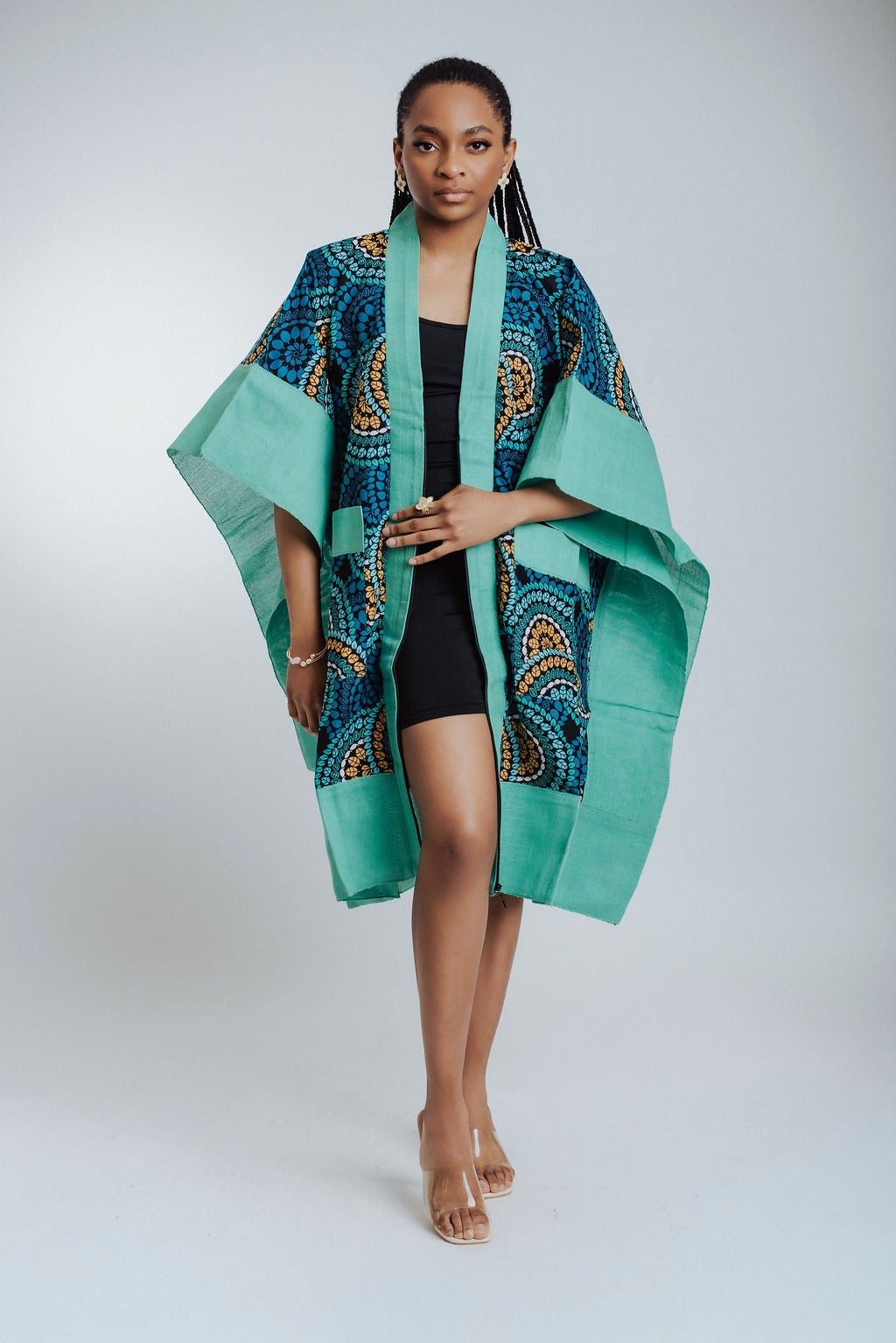 Woman wearing a teal and patterned kimono against a white background